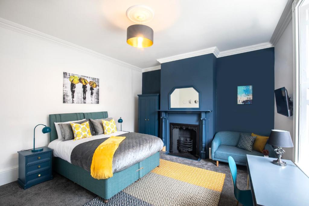 金斯林BrickSage Rooms, King's Lynn South Gate的一间卧室设有蓝色的墙壁、一张床和一张书桌