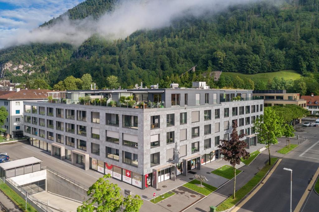 因特拉肯Swiss Hotel Apartments - Interlaken的山前的公寓楼