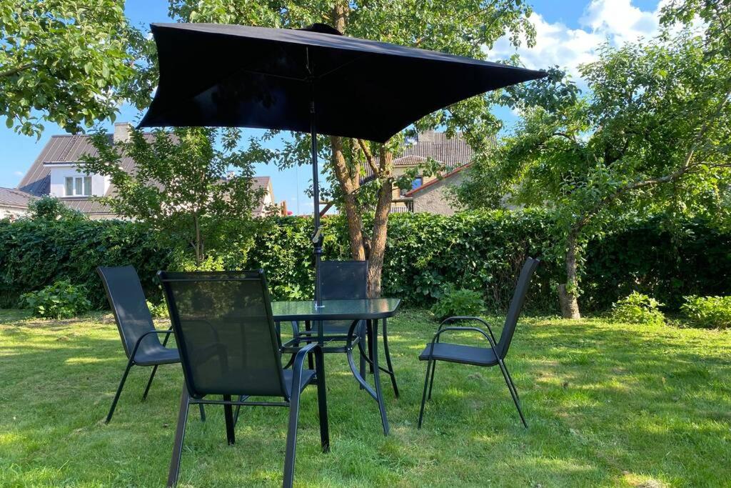 沃鲁Võru Villa, saun, grill, jalgrattad, ideaalne perepuhkus!的一把黑桌子和椅子放在伞下