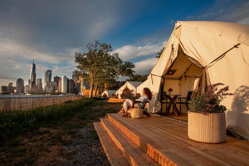 纽约Collective Governors Island的一个大帐篷,一个女人坐在木甲板上