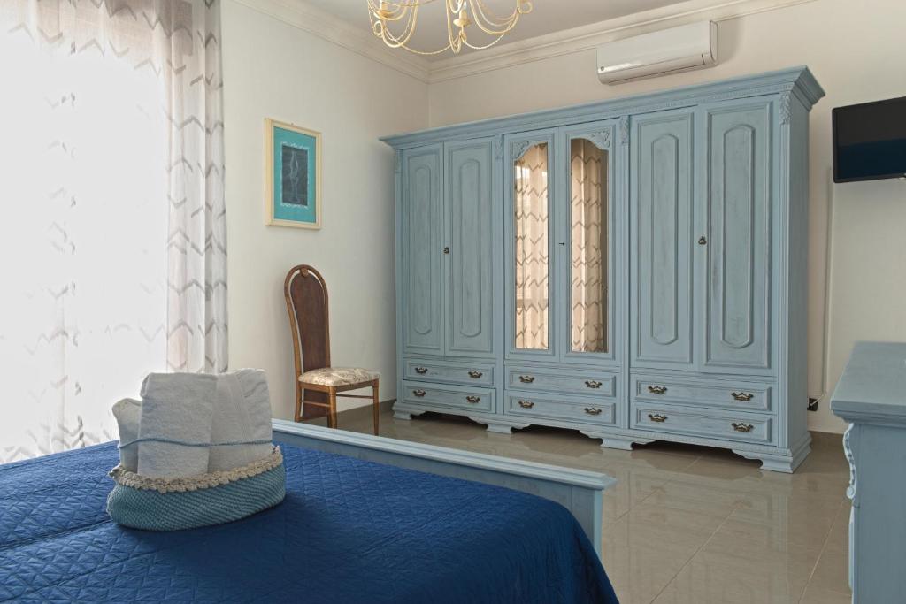 圣潘克拉齐奥萨伦蒂诺Antico Borgo的一间卧室配有蓝色的床和椅子