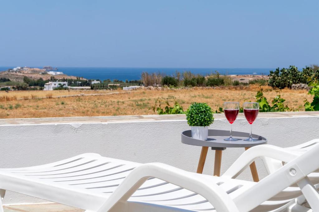 帕罗斯岛Villa Kalamies 2的阳台上的桌子上放了两杯葡萄酒