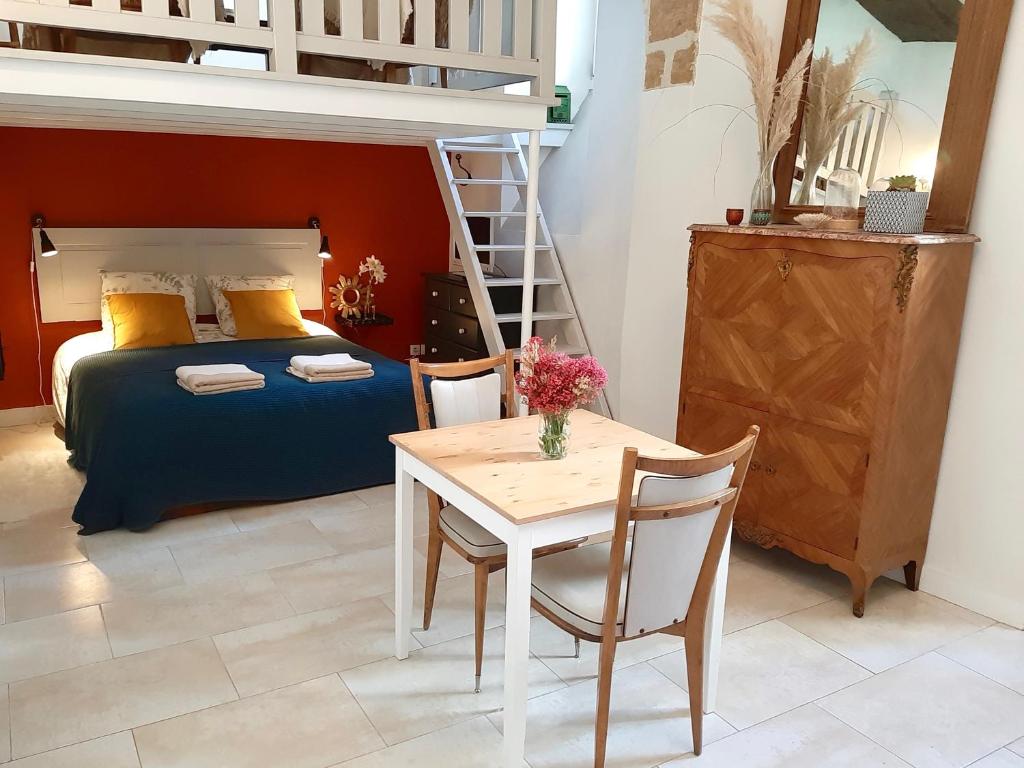 阿姆博斯En plein Coeur : charmant gite centre Amboise的一间卧室配有一张床、一张桌子和一张双层床。