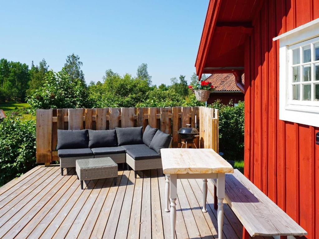 Mellösa5 person holiday home in Mell sa的木制甲板上配有蓝色沙发的庭院