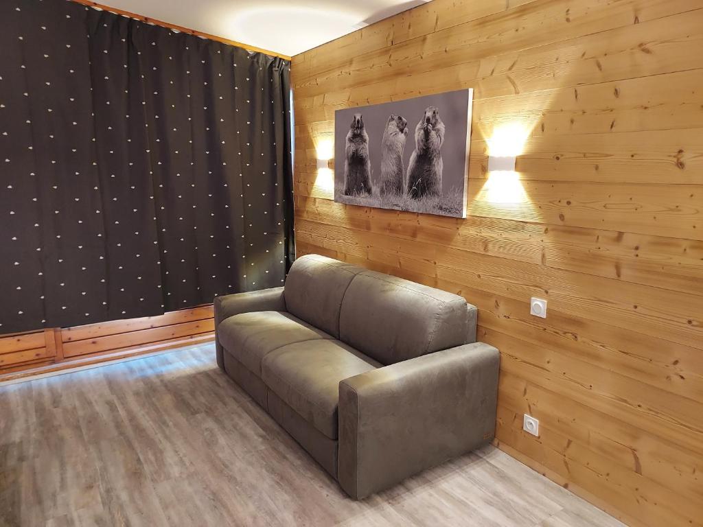 阿克1800ARC 1800, Résidence les Lauzieres的配有木墙的客房内的真皮沙发