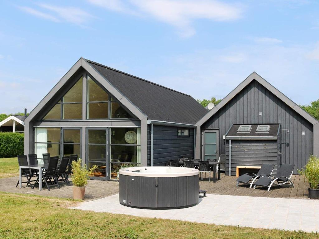 诺尔赫鲁普12 person holiday home in Hadsund的一座带庭院和烧烤架的大型黑色房屋