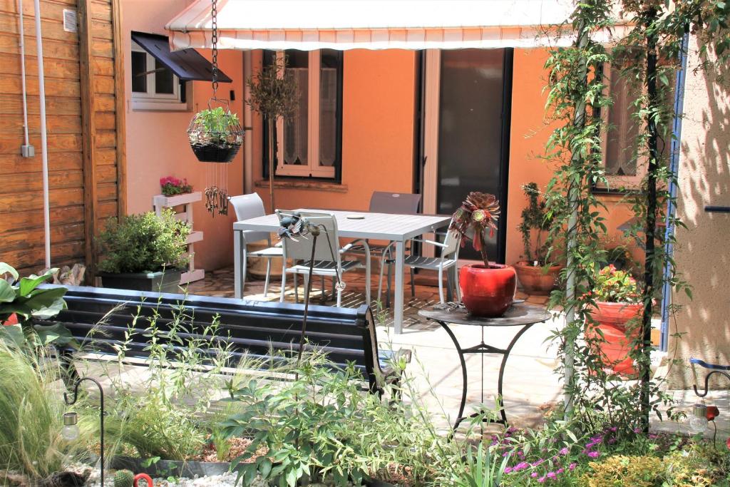 图卢兹Maison Toulousaine avec jardin的庭院配有桌椅和植物