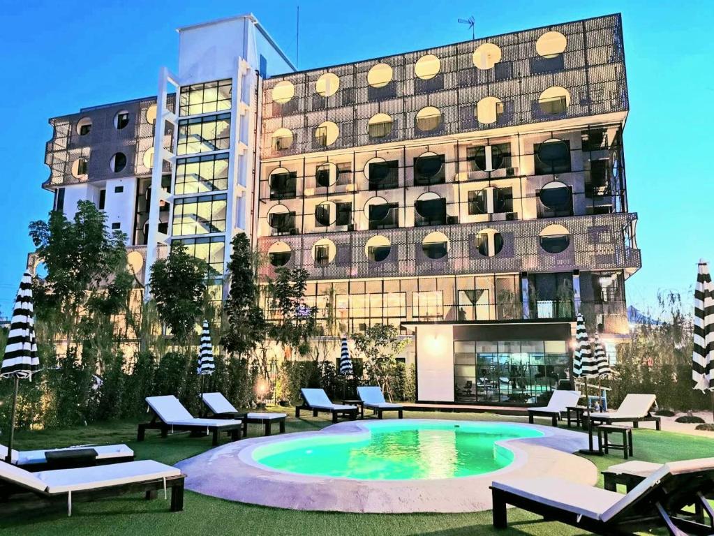 罗勇Hotel Fuse Rayong的大楼前有游泳池的酒店