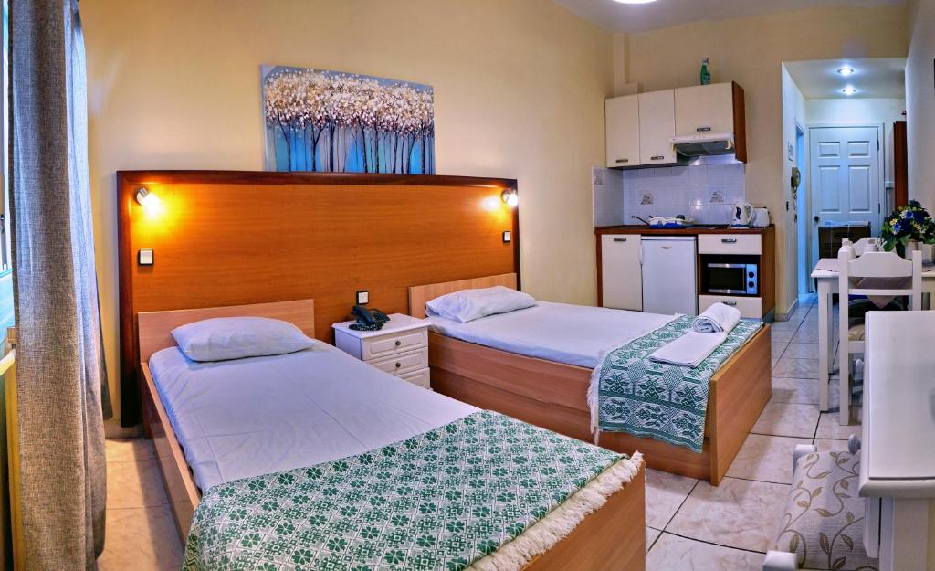 米蒂利尼Sourada Studios的酒店客房带两张床和厨房