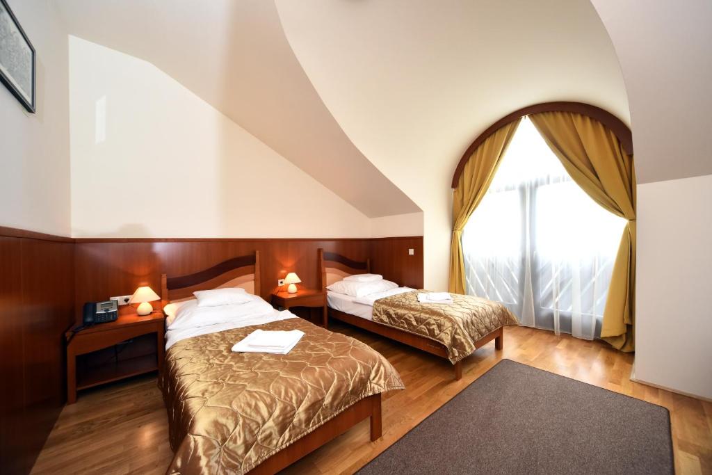 KisújszállásHotel Kumánia的酒店客房设有两张床和窗户。