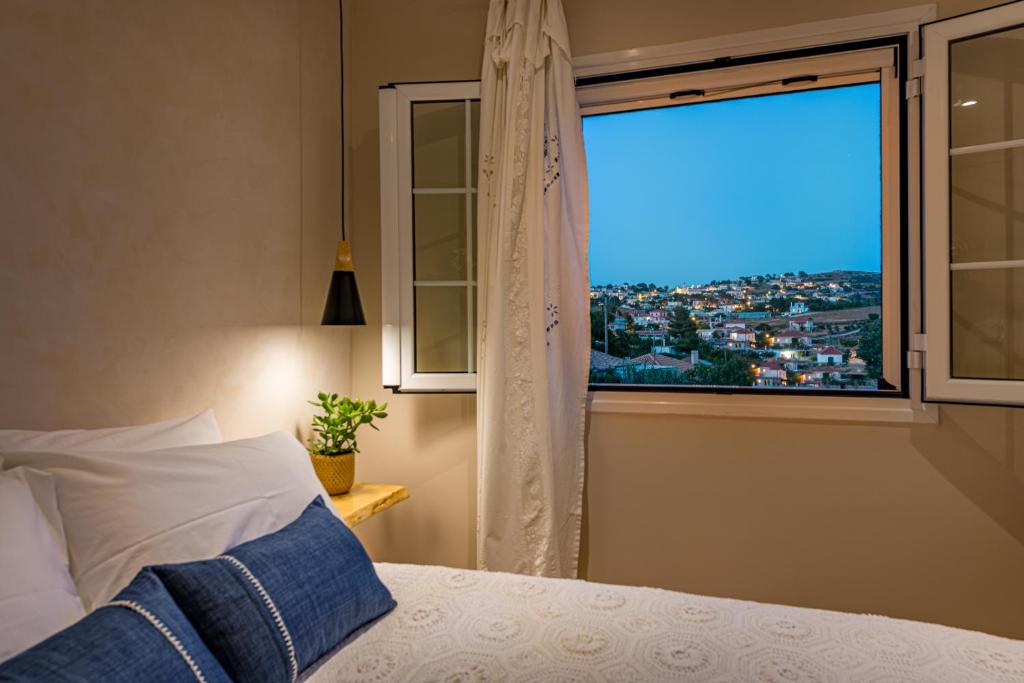 沃丽曼村Vardakis house的一间卧室设有窗户,享有城市美景