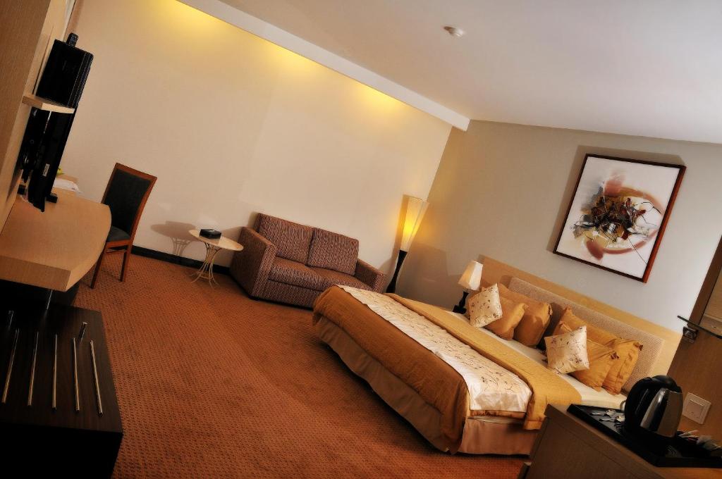 万隆万隆格兰德塞拉圣蒂布德酒店的配有一张床和一把椅子的酒店客房