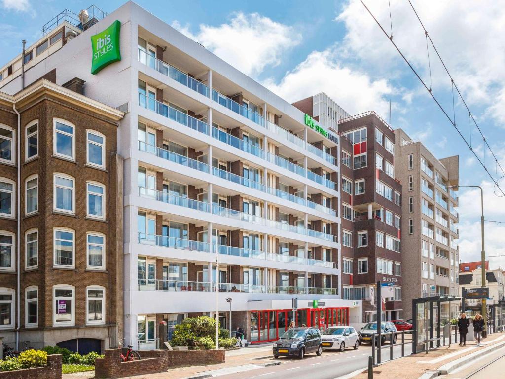 斯海弗宁恩ibis Styles Den Haag Scheveningen的街道上的公寓楼,外面有汽车停放