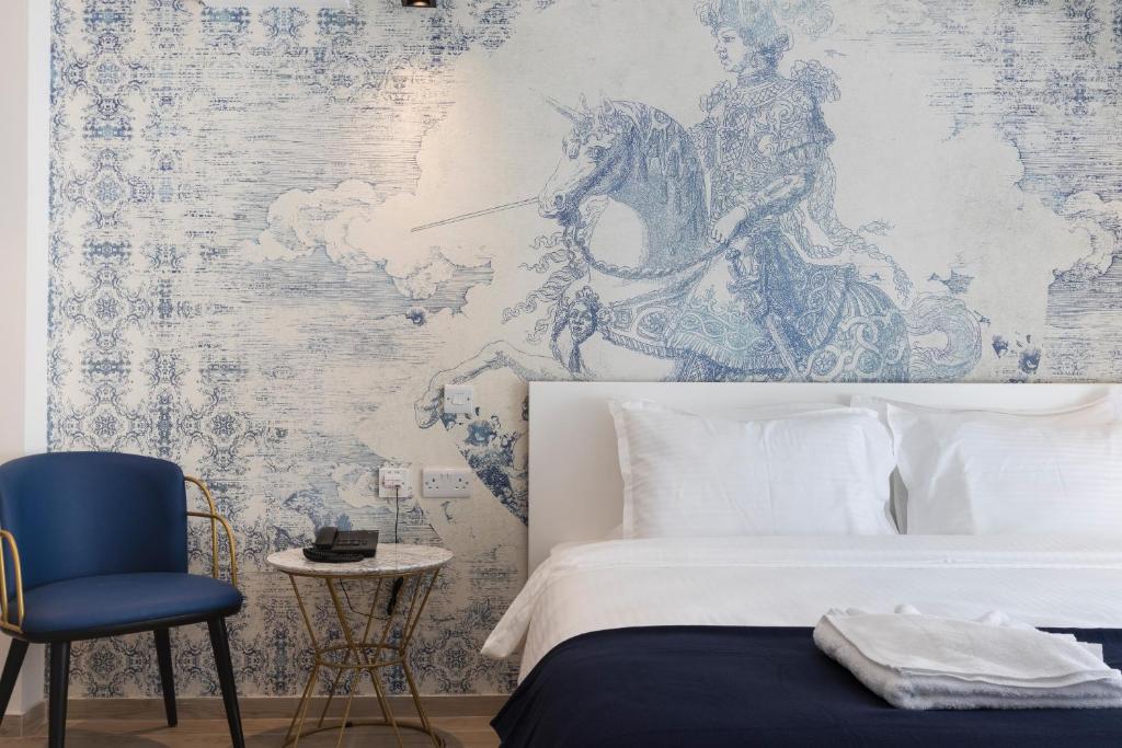 圣朱利安斯The G Hotel by JL的卧室配有白色的床和蓝色椅子