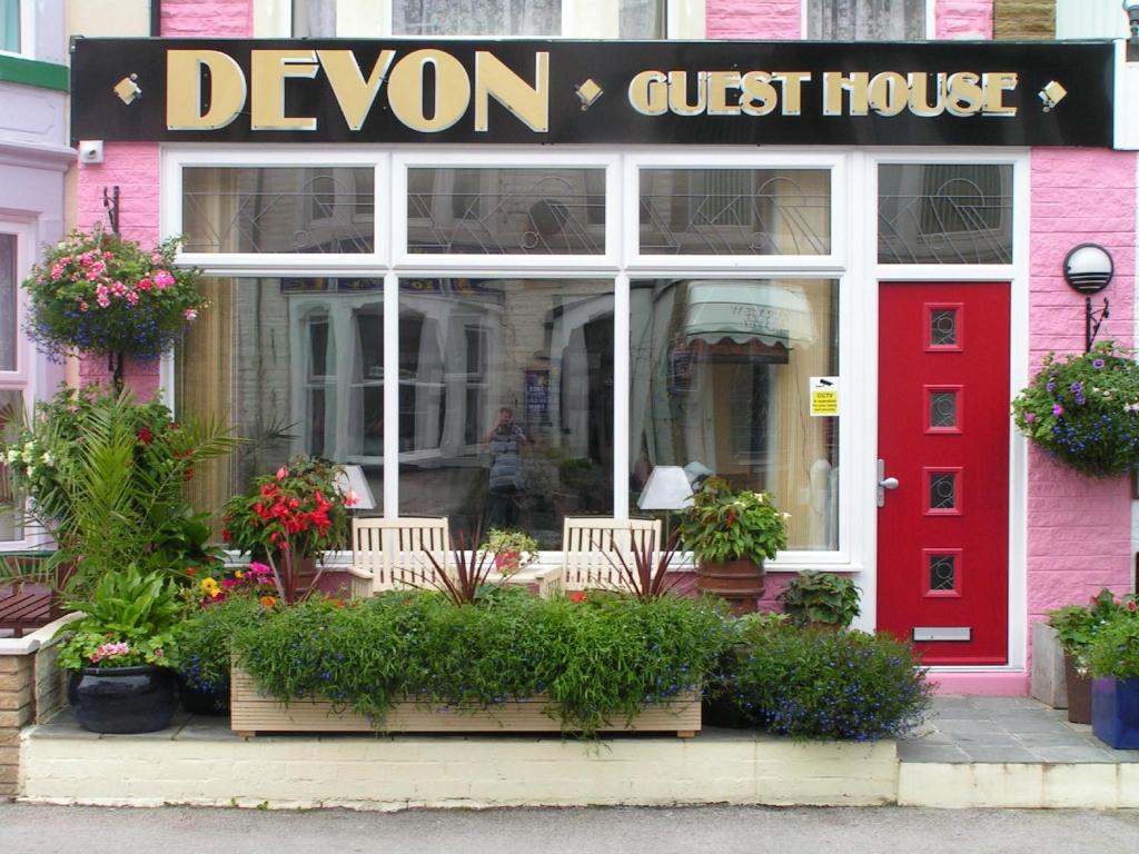 布莱克浦Devon Guest House的一间设有红色门的商店和德文郡旅馆