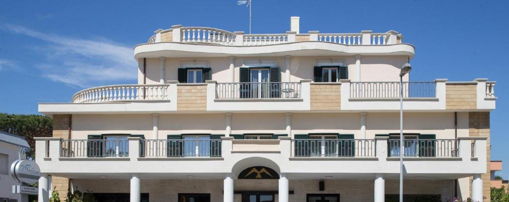 萨包迪亚Hotel Il Gabbiano的一座高大的白色建筑,设有阳台
