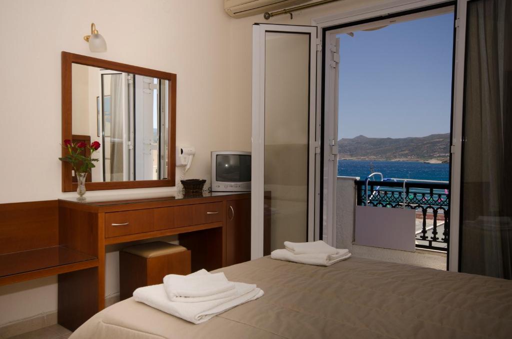 锡蒂亚依格考酒店的一间卧室配有书桌、镜子和床