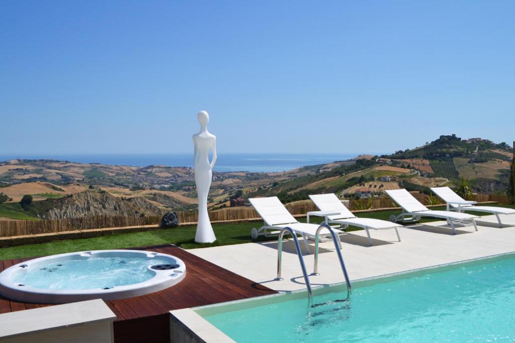 阿特里B&B & SPA Novantadieci Club的别墅 - 带一座带雕像和椅子的游泳池