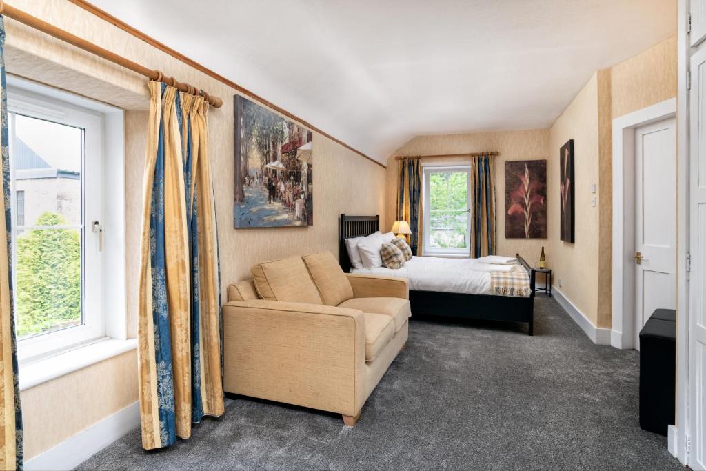 巴拉特The Green Inn Rooms的一间卧室配有一张床、一张沙发和窗户。