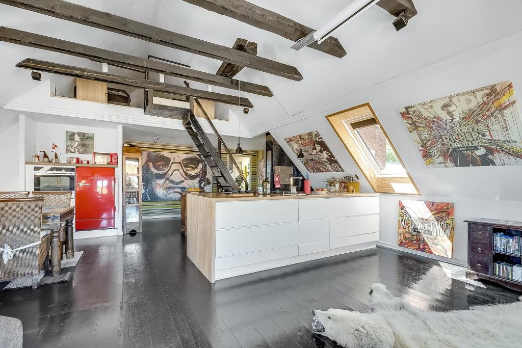 JellingGormsgade lejlighed的厨房配有白色橱柜,墙上挂有艺术品