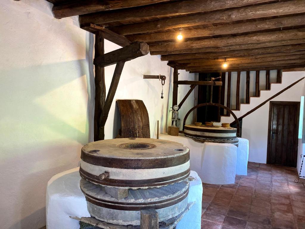 胡斯卡尔Casa Rural Molino de Bony的一间设有两个酒桶和一个楼梯的房间