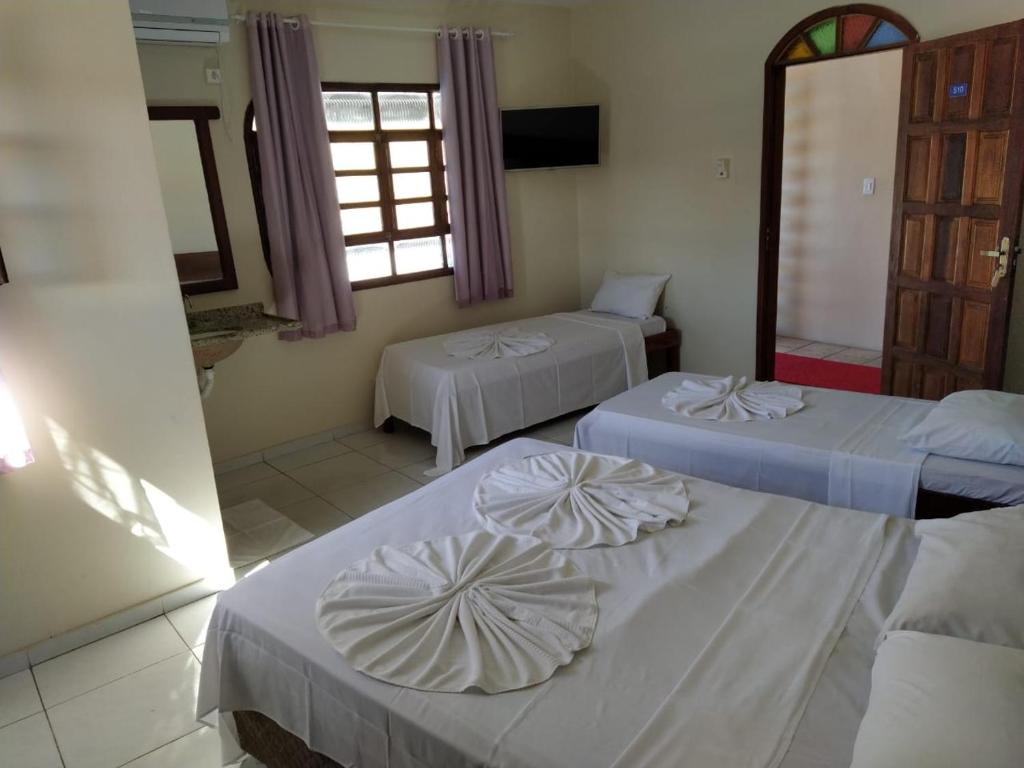 塞古罗港Hotel Sol Bahia的带三张床和窗户的客房