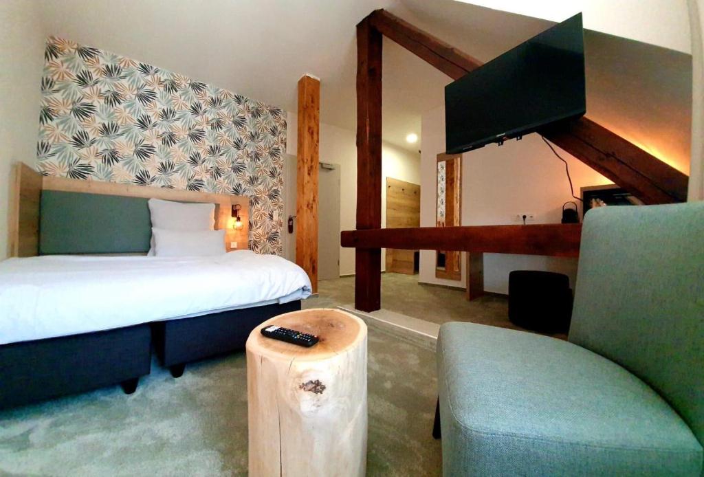 希勒Hotel Le Filou的一间卧室配有一张床、一台电视和一张沙发