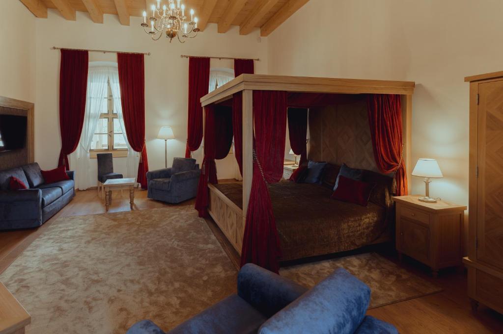 BoršaBrigadéros Hotel Brigadír Borsi的一间卧室配有一张带红色窗帘的天蓬床