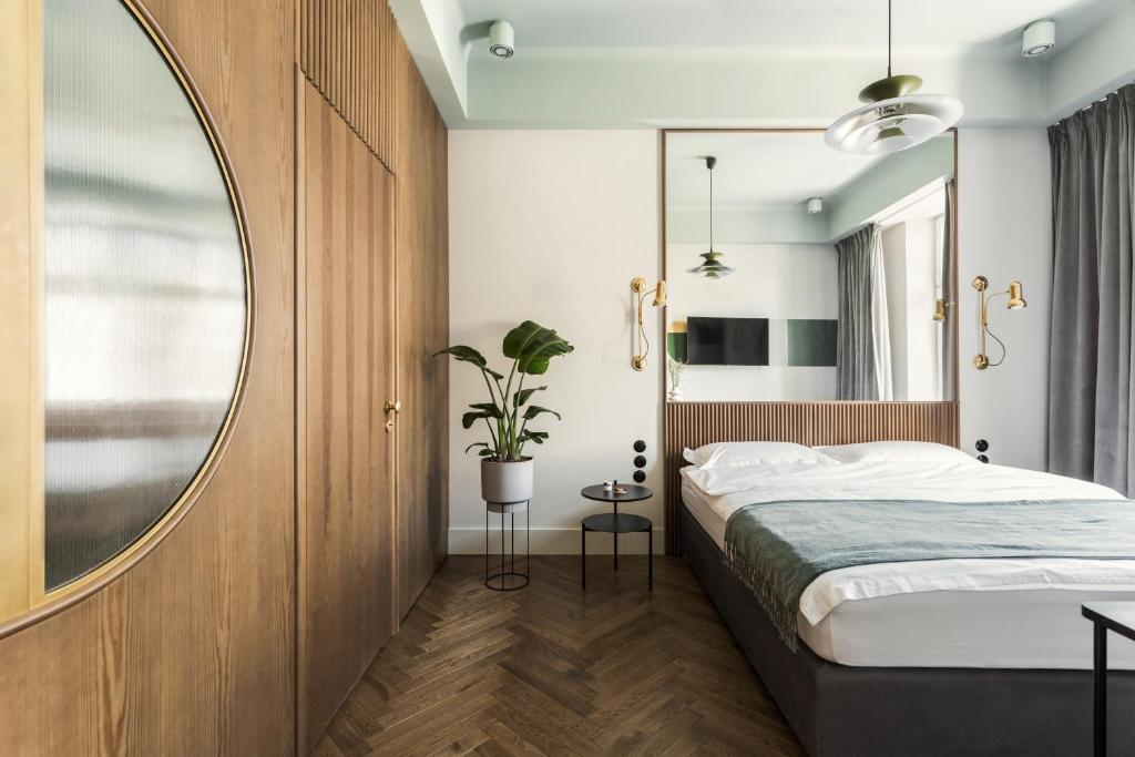 克拉科夫Angelus Apartments的一间卧室配有一张床和一面大镜子