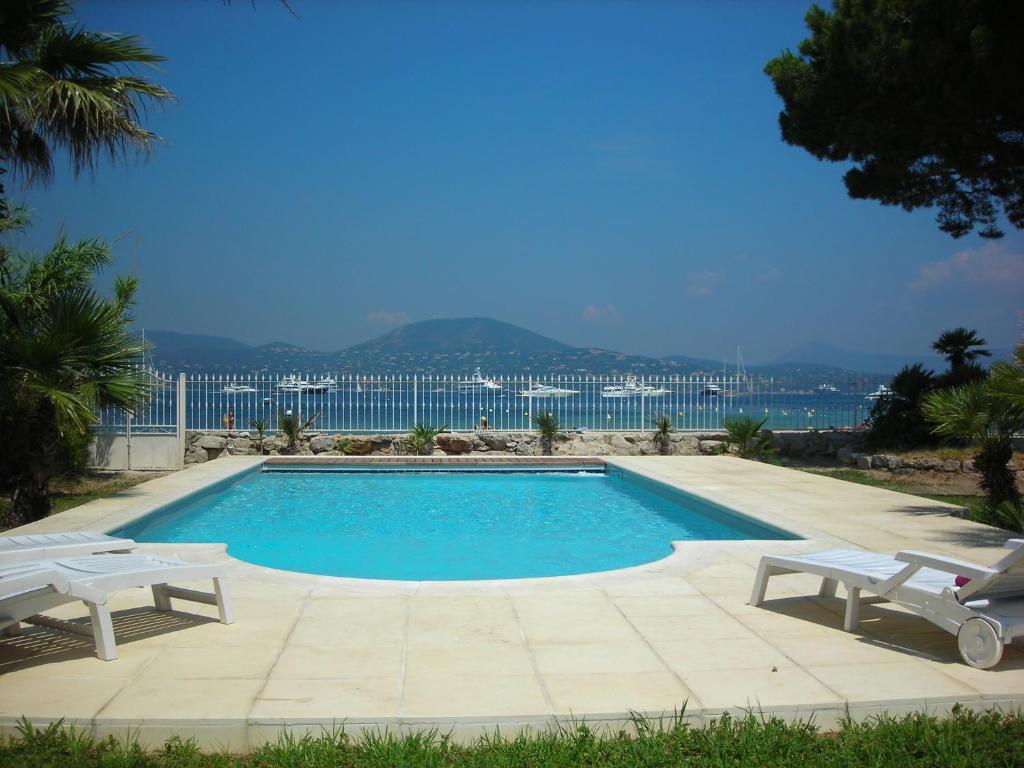 圣特罗佩Villa Playa del Sol - B2的一个带两把白色椅子的游泳池以及大海