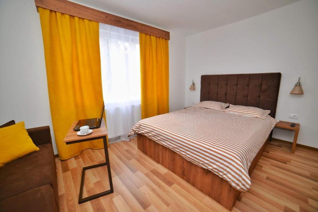 比耶利纳Studio apartmani Emili Bijeljina apartman br 1的一间卧室配有一张床、一张桌子和一个窗户。