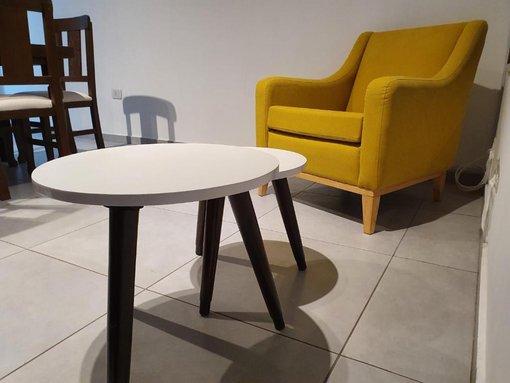 门多萨Apartamento Deluxe Senderos del Vino II, desayuno Opcional的白色桌子和黄色椅子