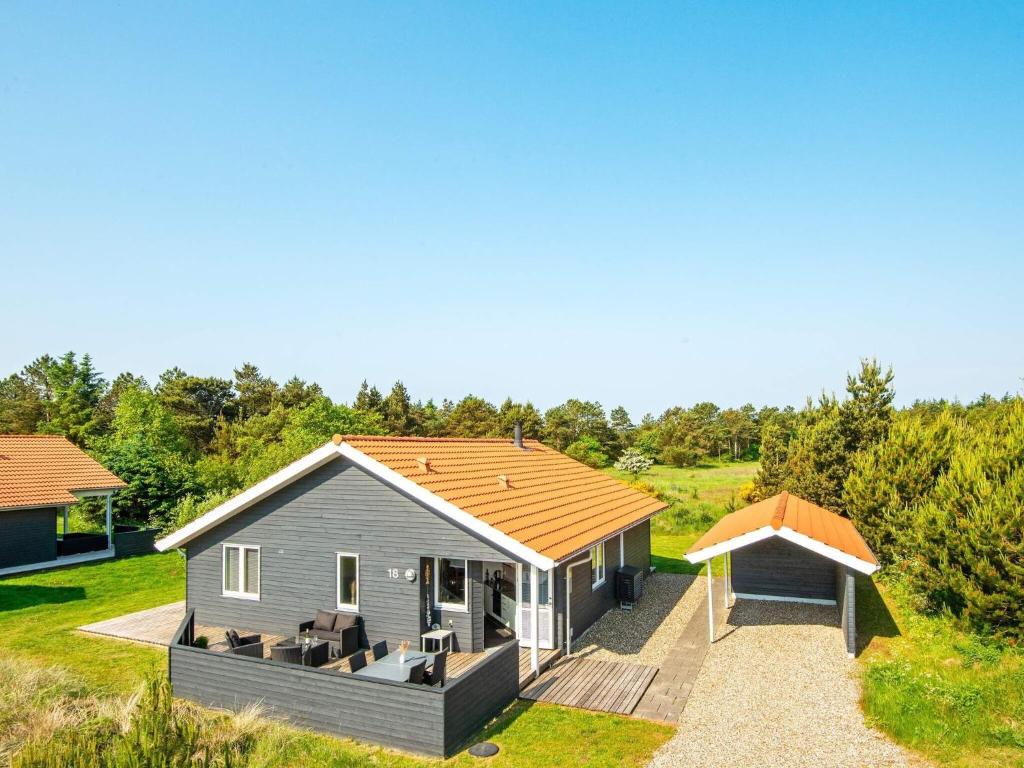 法贾德嘉德8 person holiday home in Ulfborg的田野上带屋顶的小房子