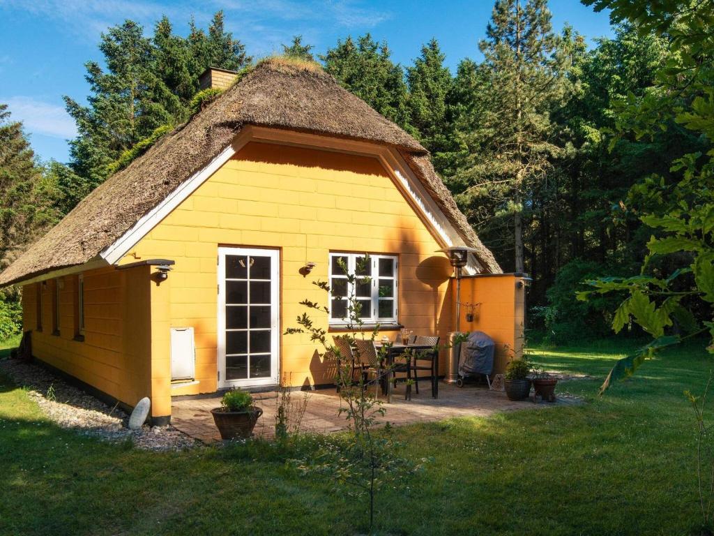 乌尔夫堡Holiday home Ulfborg XXIII的小屋拥有茅草屋顶,是一座黄色的小小屋