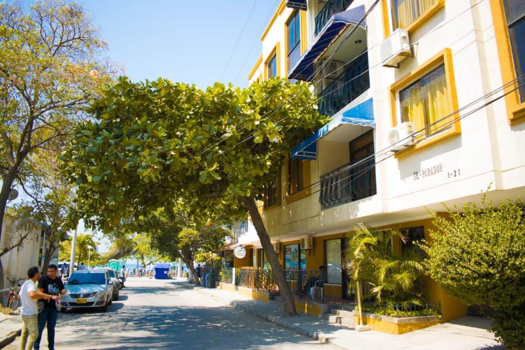 圣玛尔塔Acogedor apartamento a 15 metros del mar的两个人沿着大楼旁边的街道走