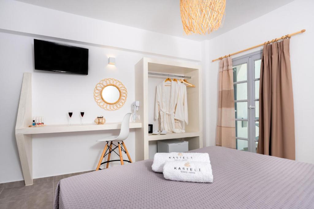 佩里萨Kasteli Luxury Rooms的一间卧室配有一张床、一张书桌和一面镜子