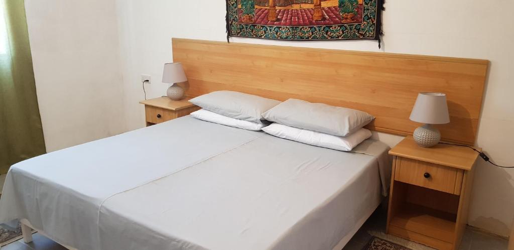 SiġġiewiAuberge de Provence的卧室配有一张带两盏灯的白色床和一幅画
