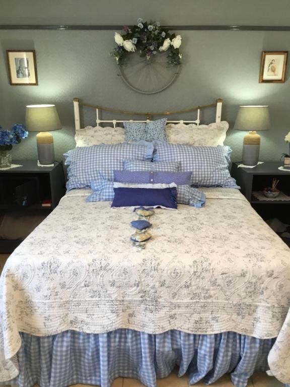 SouillacAurelia Lodge - Apartment with Terrace的一张带蓝色和白色床单及枕头的床