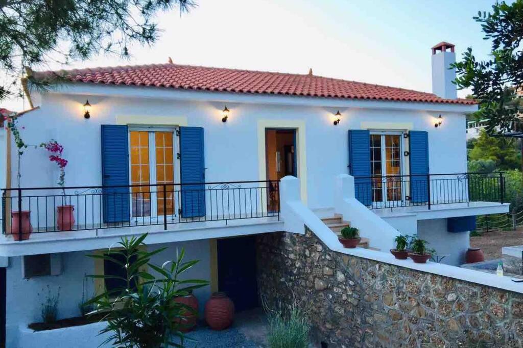 波多河丽Gerani Maison Agios Aimilianos beautiful view的一座带蓝色百叶窗和石墙的房子
