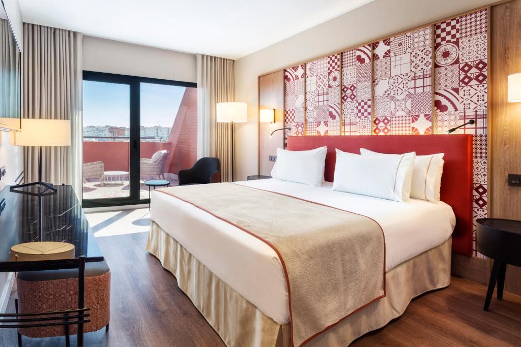 塞维利亚Eurostars Guadalquivir的酒店客房设有一张床和一个阳台。