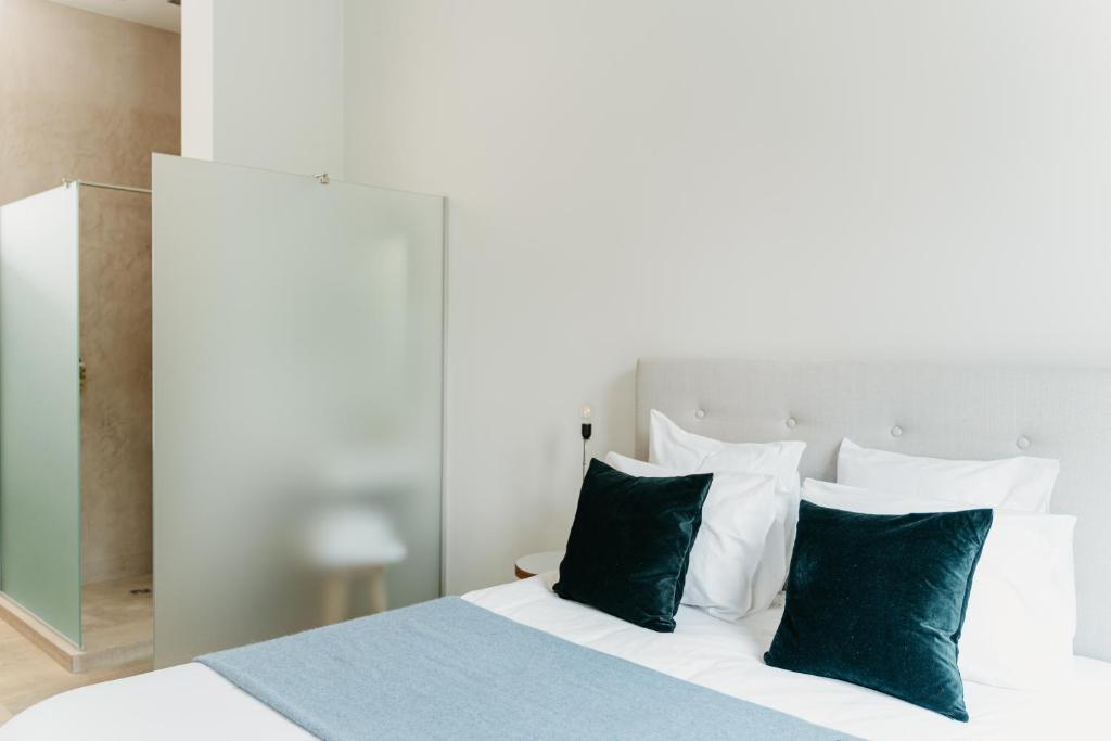 安特卫普The 1880 Residence by Domani Hotels的一间卧室配有带绿色和白色枕头的床