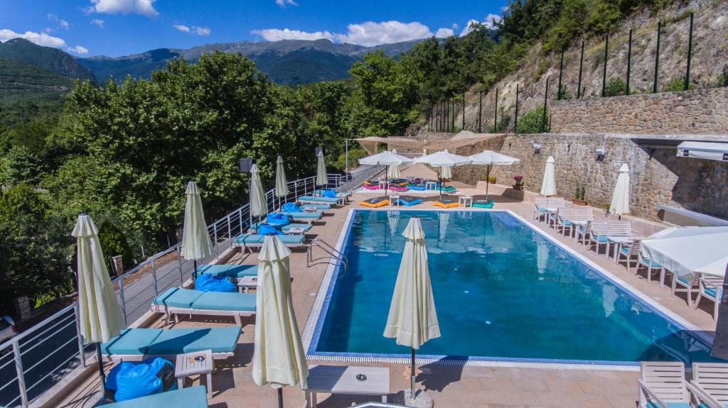 卡托劳塔翁尼姆菲斯酒店的游泳池,带椅子和遮阳伞