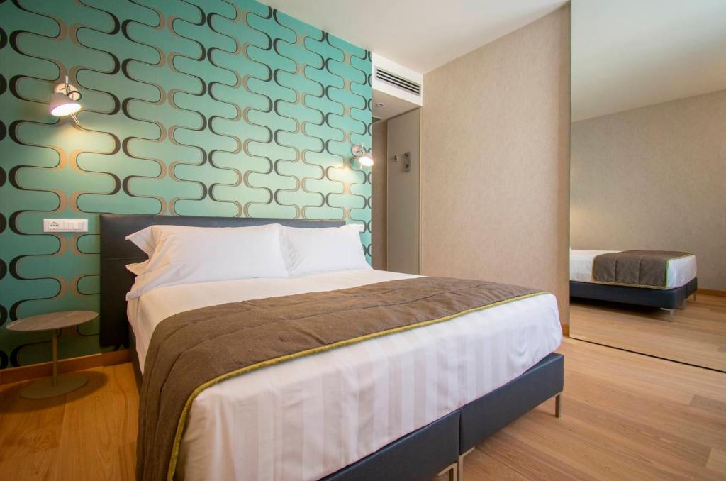 利多迪卡马约雷Hotel Medusa的一间卧室设有一张床和绿色的墙壁