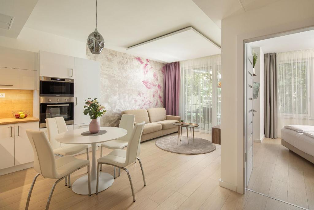 赫维兹Spa Residence Carbona Hévíz - Relax, Sissi Apartmanok的厨房以及带桌椅的起居室。