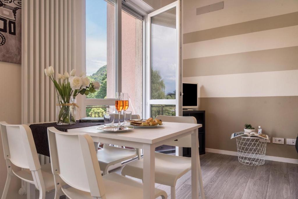 拉韦诺-蒙贝洛Maison Bibi Lago Maggiore的一间带桌椅和窗户的用餐室