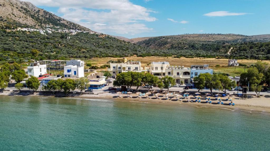 利瑟昂Almiriki Chios Rooms & Apartments的享有海滩美景,设有椅子和建筑