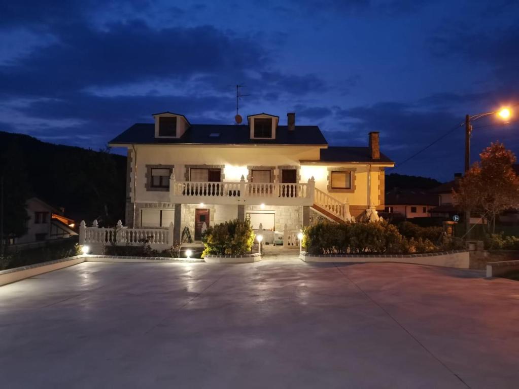 乌迪亚莱斯堡Casa La Quintana的一间大型的白色房子,晚上有车道