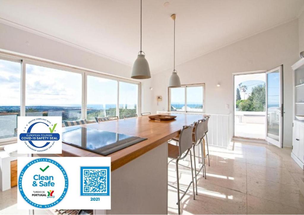 阿尔卡彼得克Sea View Cascais Design Villa的厨房设有大岛,配有椅子和窗户