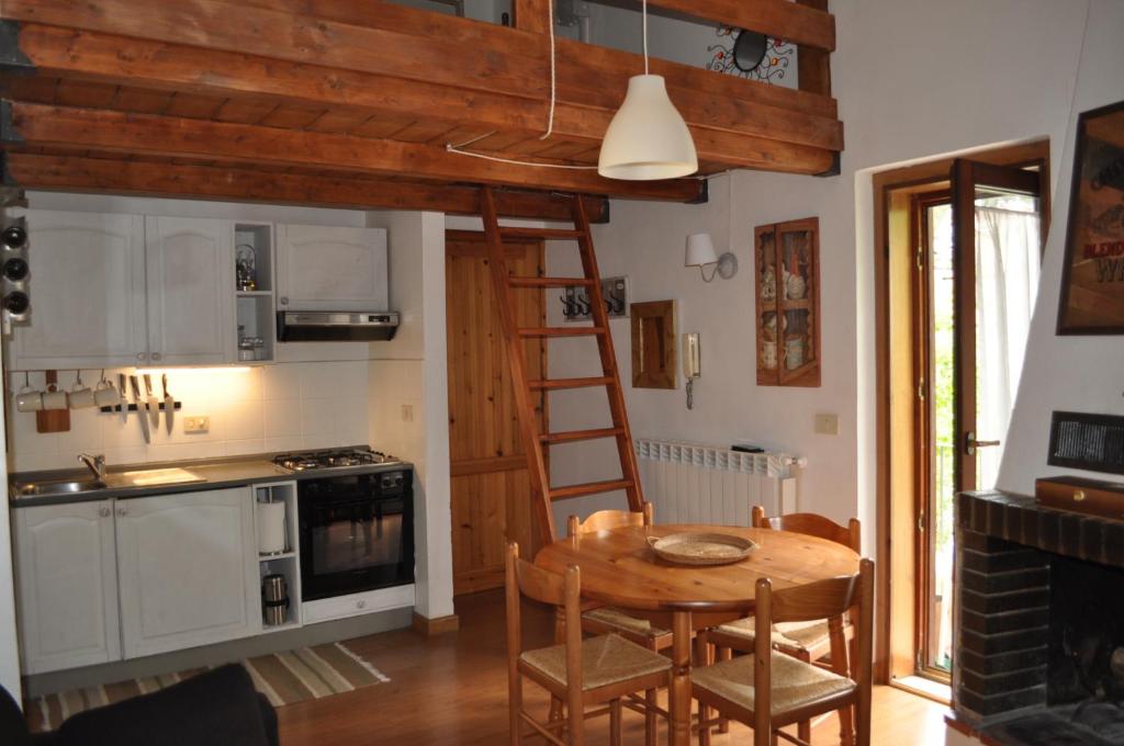 奥温多利Appartamento ad Ovindoli的厨房配有木桌和梯子