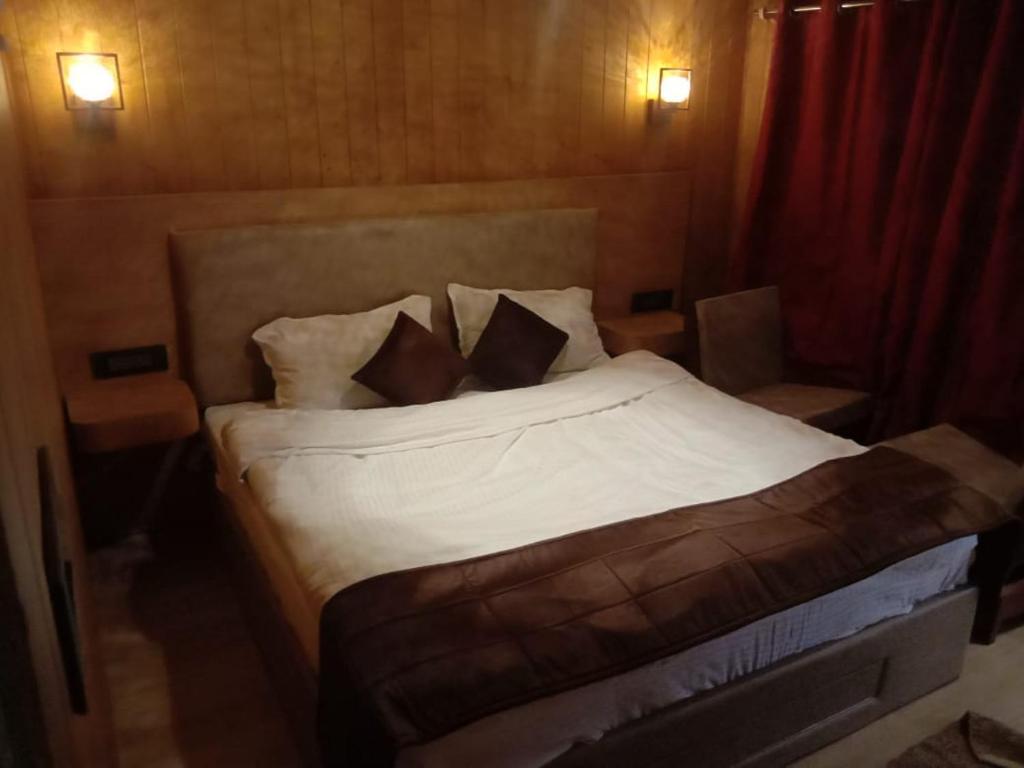 兰斯顿Highlander-guesthouse的一间卧室配有带白色床单和枕头的床。